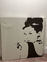 Front view of the Audrey Hepburn canvas showing a black and white stylized portrait with some wrinkles or dents on the canvas surface.