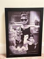Front view of the framed 3D black and white Audrey Hepburn poster showing multiple poses of the actress in vintage attire.