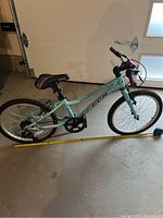 Side profile of teal and purple CCM children's bike showing 52 cm frame and tires