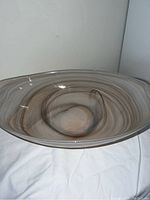Front angled view of oval glass bowl showing swirl pattern and gentle rim.