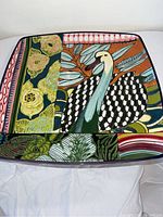 Top view of square decorative platter with colorful stylized swan and floral patterns