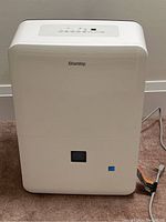 Front view of white Danby dehumidifier showing top mounted control panel and front water level window.
