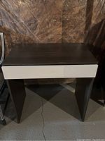 Full front view of dark grey and white modern desk with single drawer.