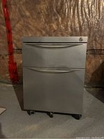 Front view of the silver two-drawer file cabinet on wheels, showing the handles and lock on the top drawer.
