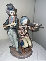 Front view of Lladró clown figurine showing two clowns with musical instruments on a porcelain base.