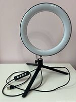 Desk ring light on a black tripod stand with USB plug and control inline on the cable.