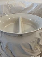 Top view of the white ceramic serving dish showing two compartments divided by a central partition. Oval shape with a glossy finish.