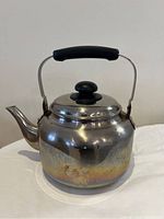 Photo of the stainless steel tea kettle showing the overall shape, handle, and discoloration on the lower body.