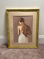 Custom framed artwork showing a woman from behind wrapped in a white cloth against a neutral background.