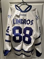 Back of the white CCM hockey jersey showing 'LINDROS' name and number 88 in blue.