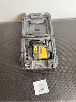 Dewalt yellow and black laser level inside black molded plastic carrying case showing tool and case wear.