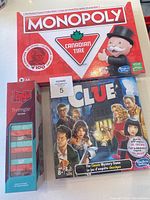 Photo of Monopoly Canadian Tire Edition, Clue classic mystery game, and Jenga Triangle Edition boxed games