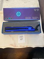T3 3880 Revolution Tourmaline hair straightener in brilliant blue inside original box with blue and purple packaging.