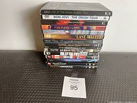 Stack of 12 music concert DVDs featuring live performances from various artists and bands as per seller's description.