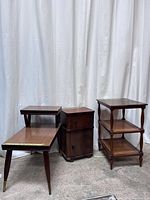 Front and side view of three vintage wooden side tables together showing design and structure
