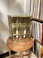 Photo showing front and top view of brass framed glass wall sconce with nine glass squares and two light sockets inside.