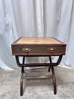 Front view of chess table with closed drawer, brass hardware, and checkered chessboard top.