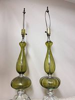 Pair of green glass table lamps with silver bases and metal harp frames shown from the front.