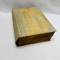 Full view of bound book with vellum spine and thick yellowed pages, showing the size and condition of the volume.