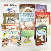 Top-down photo showing all 14 children's books arranged flat on a white surface.