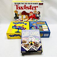Overview photo showing all four games in lot: Twister, Topple, Look Who's Listening, and Hoyle Card Games 2001