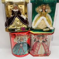 Full view of the four boxed Holiday Barbie dolls stacked two by two, showcasing different holiday-themed dresses and packaging.