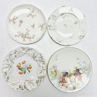 Four different plates arranged on white textured surface showing top designs and edge details