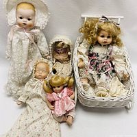 Wide shot of five dolls with two wicker furniture pieces