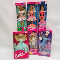 Full view of six boxed Barbie dolls in original packaging showing various themes and outfits