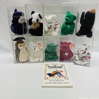 Ten TY Beanie Babies in clear plastic display cases along with The Beanie Baby Handbook displayed in front.
