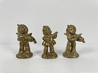 Front view of three brass figurines; children playing violin and guitar