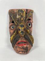 Front view of the antique Mexican wooden mask showing carved features and painted tarantula on the nose.