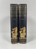 Front spine view of two hardcover books showing gold embossed text and imagery on dark cloth covers.