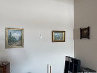 View of the three paintings hanging on the wall together showing size relation and framing styles.