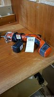 Black & Decker HandiSaw placed on a wooden surface with the power cord coiled alongside and a tag with lot number 593.