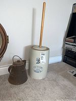 Photo of the ceramic butter churner and metal kettle side by side showing entire items and relative scale.