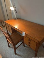 Overall view of the wooden desk with chair and lamp