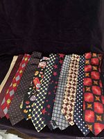 Photo showing all 11 differently patterned men's silk ties laid out side by side to display each pattern and color.