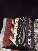 All twelve men's silk ties laid out side by side showing full variety and patterns