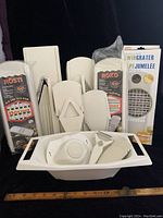 Full display of all 13 pieces including multiple mandolin slicers, blade inserts, and graters arranged against black background