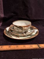 Full set photo showing cup, saucer, dessert plate stacked, ruler included for scale.