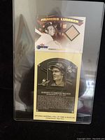 Lot in protective sleeve showing both the bat card and the Hall of Fame postcard together.