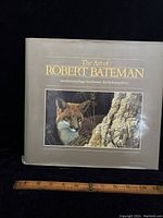 Front cover of The Art of Robert Bateman book showing wildlife painting of a cougar and part of rock face, with gold text and introduction credits.
