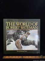 Front cover of the book 'The World of Robert Bateman' featuring a painted image of a squirrel on a tree branch and gold title text.