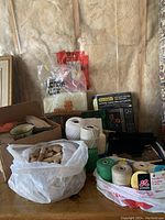 Wide view of the craft box lot showing corks, multiple colored spools of string, and craft kits.