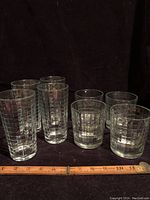 Group photo of all 8 drinking glasses (4 highball and 4 old fashioned) next to a ruler for size reference