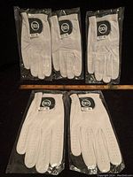 Five white men’s golf gloves in size XL for the right hand, individually packaged with SG logo tags visible.