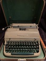 Front view of Remington Quiet-Riter typewriter inside open case, showing keyboard, roller, and Remington branding