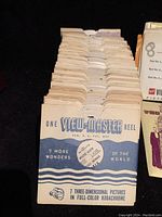 Stack of vintage View-Master reels in original cardboard sleeves marked 'One View-Master Reel' with 7 3D Kodachrome pictures.
