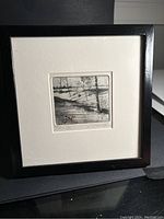 Full view of framed landscape print showing black frame and white mat with print inside.